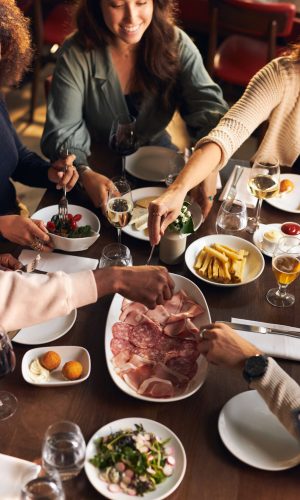 Friends helping themselves to food in restaurant